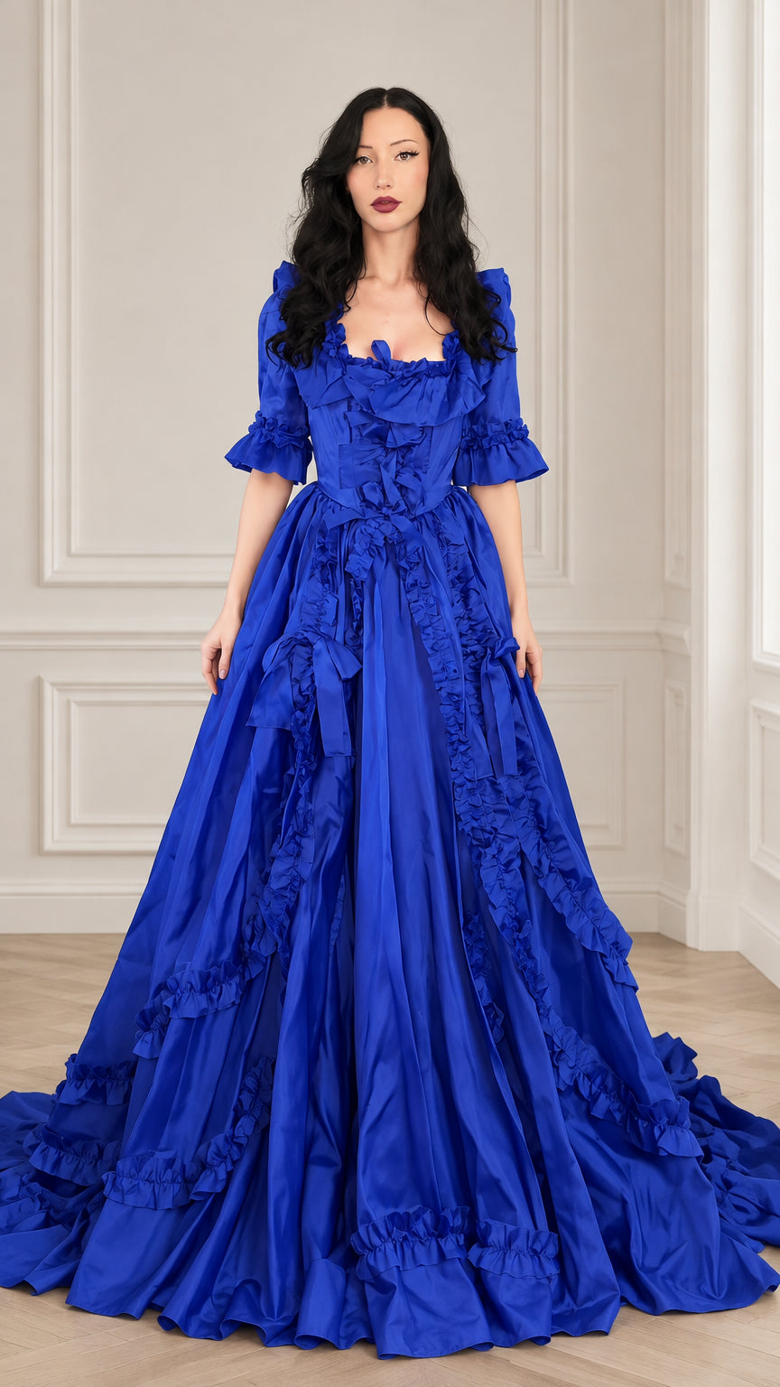 Front full view of woman wearing a royal blue Victorian ruffled ball gown dress