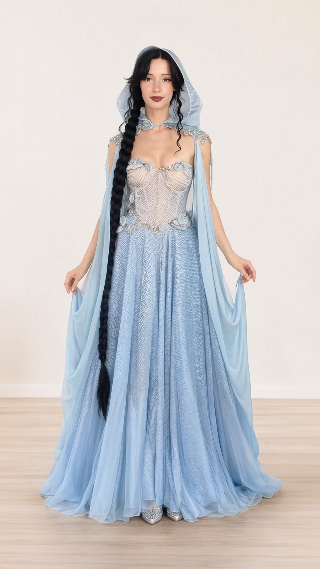 Front view of model wearing light blue hooded corset maxi gown with sweeping cape