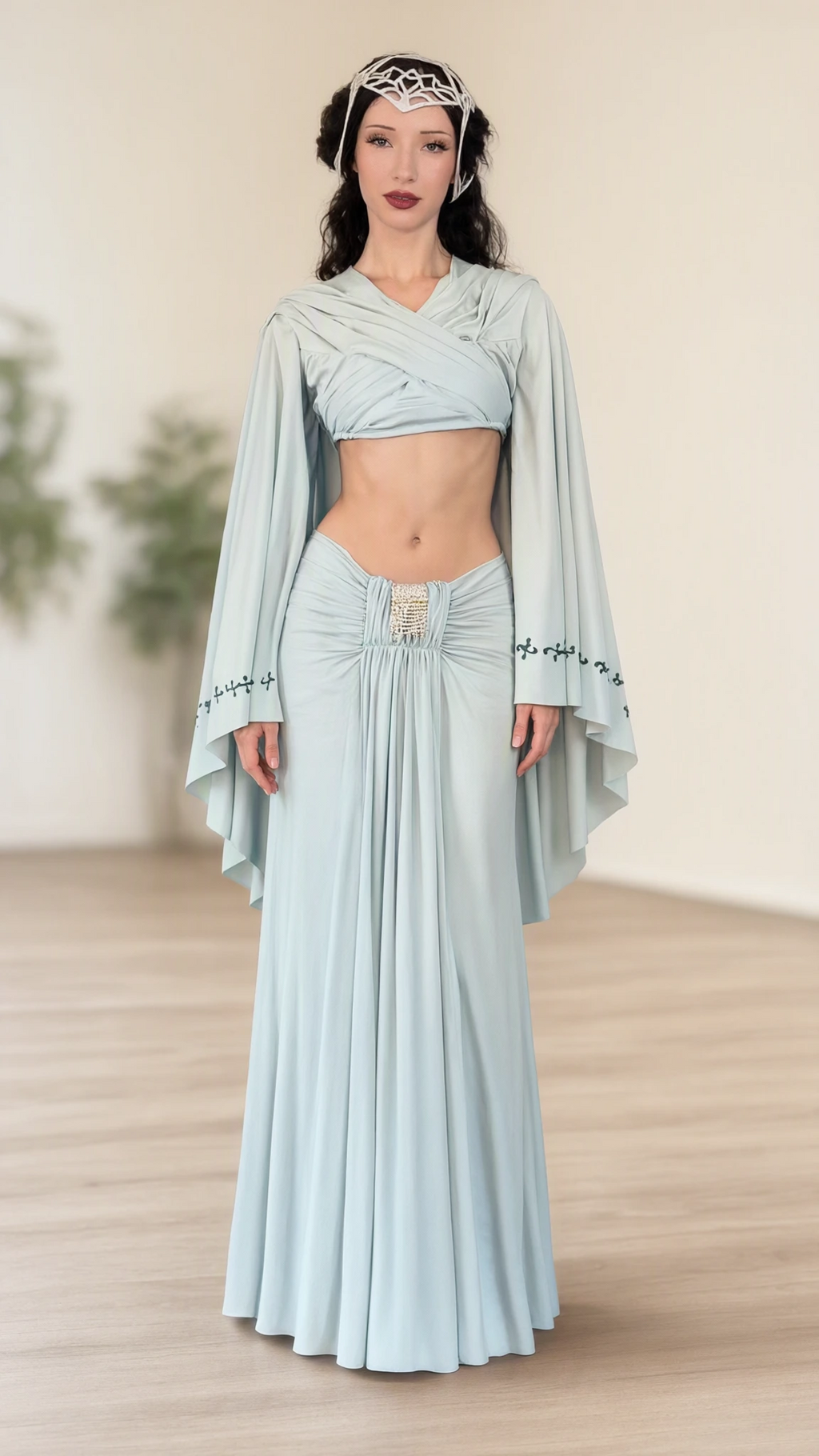 Front full-length view of model wearing light blue fantasy capelet crop top and ruched maxi skirt set