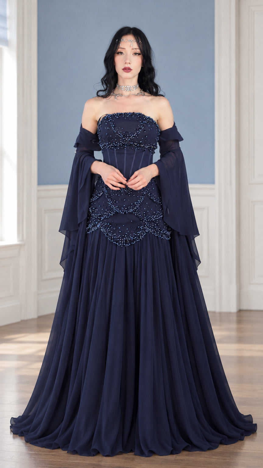 Front full view of woman wearing navy blue strapless beaded corset evening gown with draped sleeves