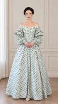 Front full view of woman wearing sage green vintage floral off-shoulder ball gown with tiered puff sleeves