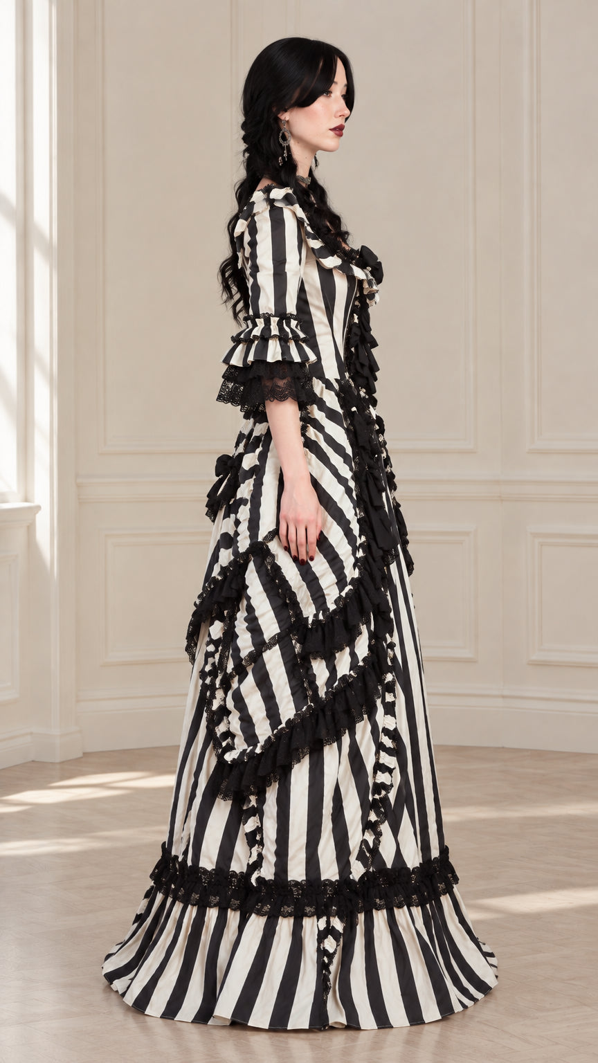 Side profile view of black and white striped Victorian gown showing ruffled bustle drapery