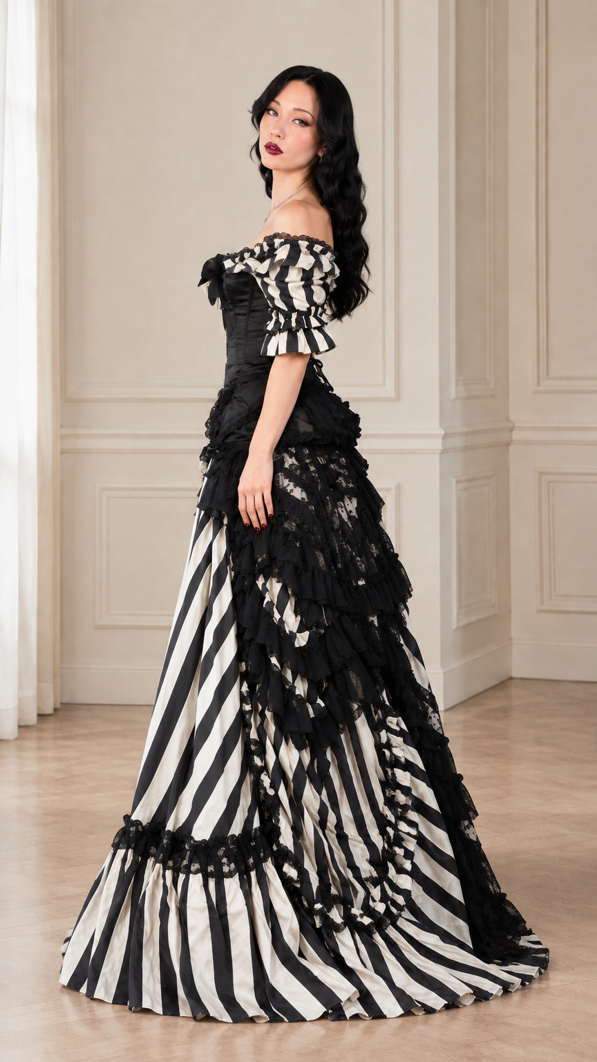 Side profile of model in black and white striped Victorian ball gown with bustle detail