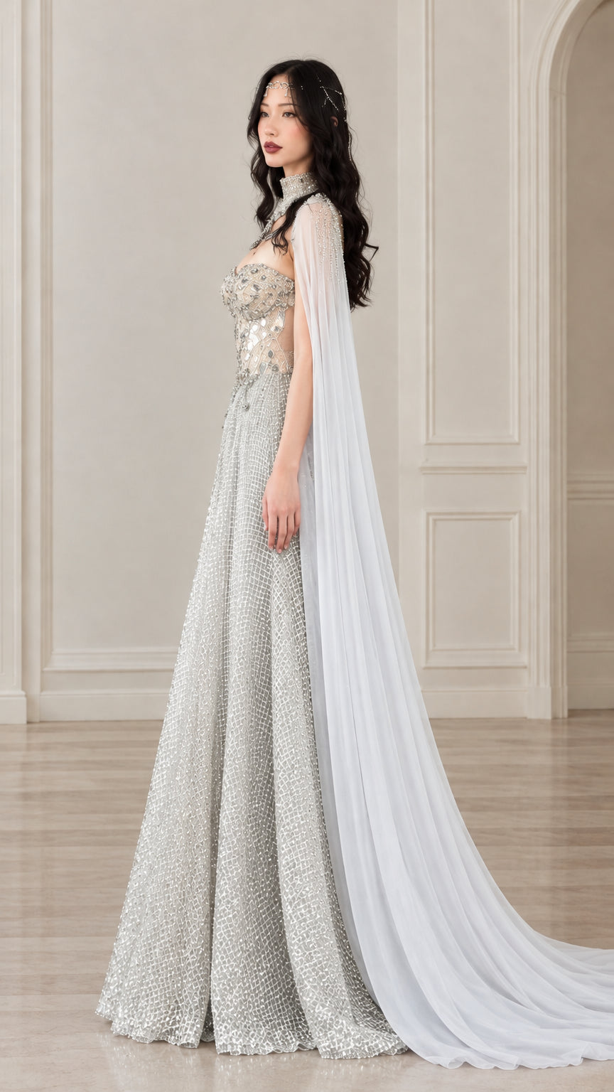 Side profile view of silver embellished evening dress showcasing the draped cape train and A-line silhouette