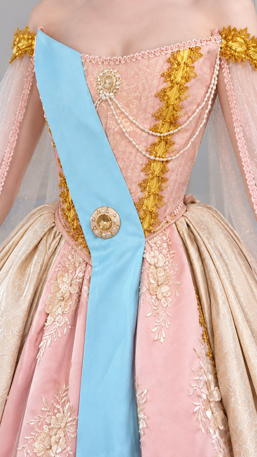 Bodice close-up showing gold lace detailing, pearl strands, and blue sash badge