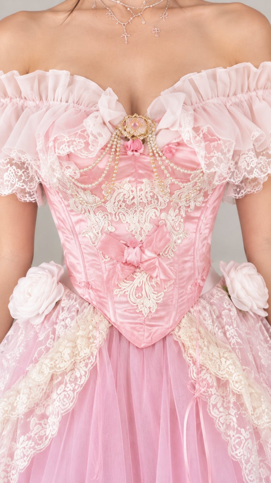 Close-up detail of the pink bodice showing intricate floral lace applique, pearl beading, and sweetheart neckline