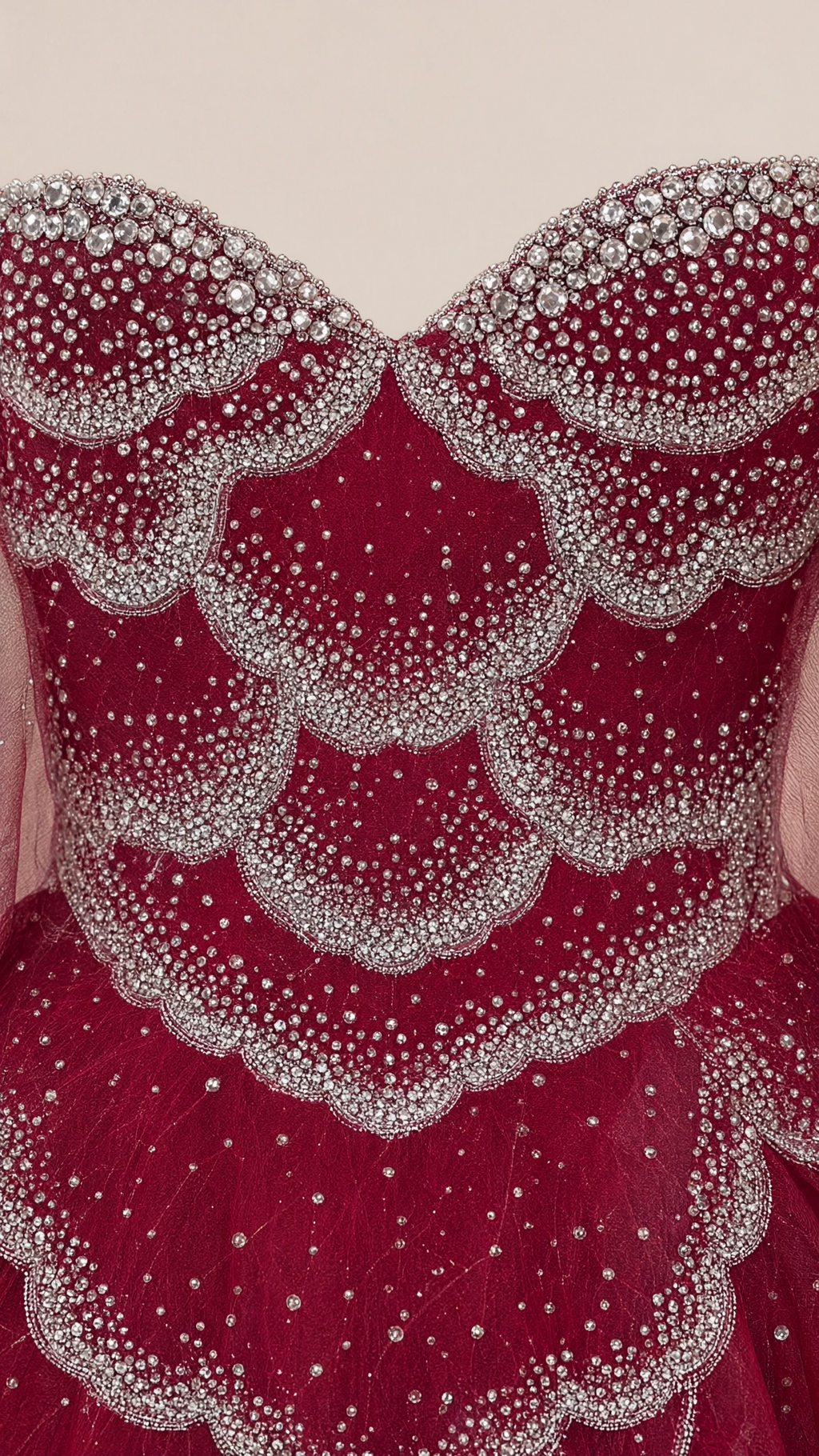 Close-up detail of scalloped rhinestone beaded petal bodice on burgundy tulle gown