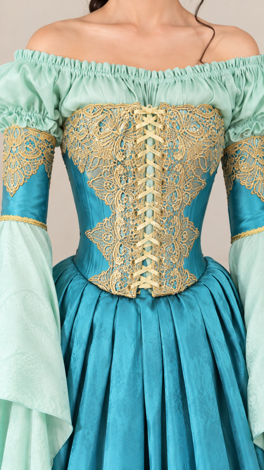 Close-up detail of Teal Blue gown featuring intricate gold embroidered lace-up bodice and ruffled off-shoulder neckline