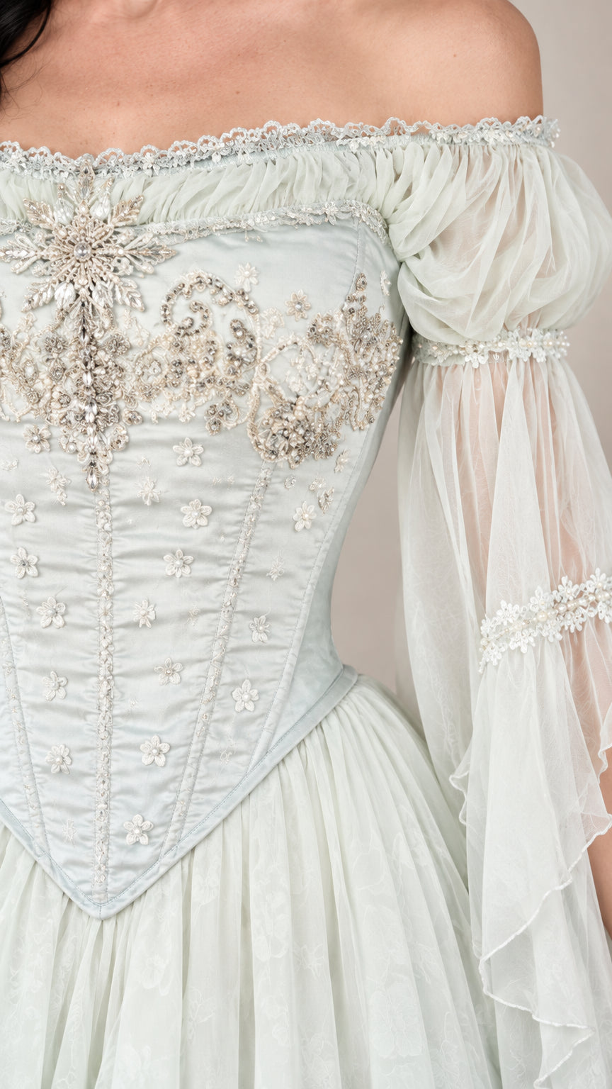 Close-up detail of the off-shoulder neckline, floral embroidery, and basque corset bodice