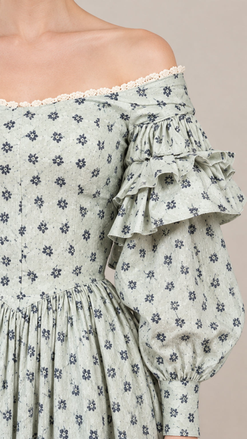 Close-up detail of off-shoulder lace trim, ditsy floral pattern, and tiered ruffle sleeves on gown