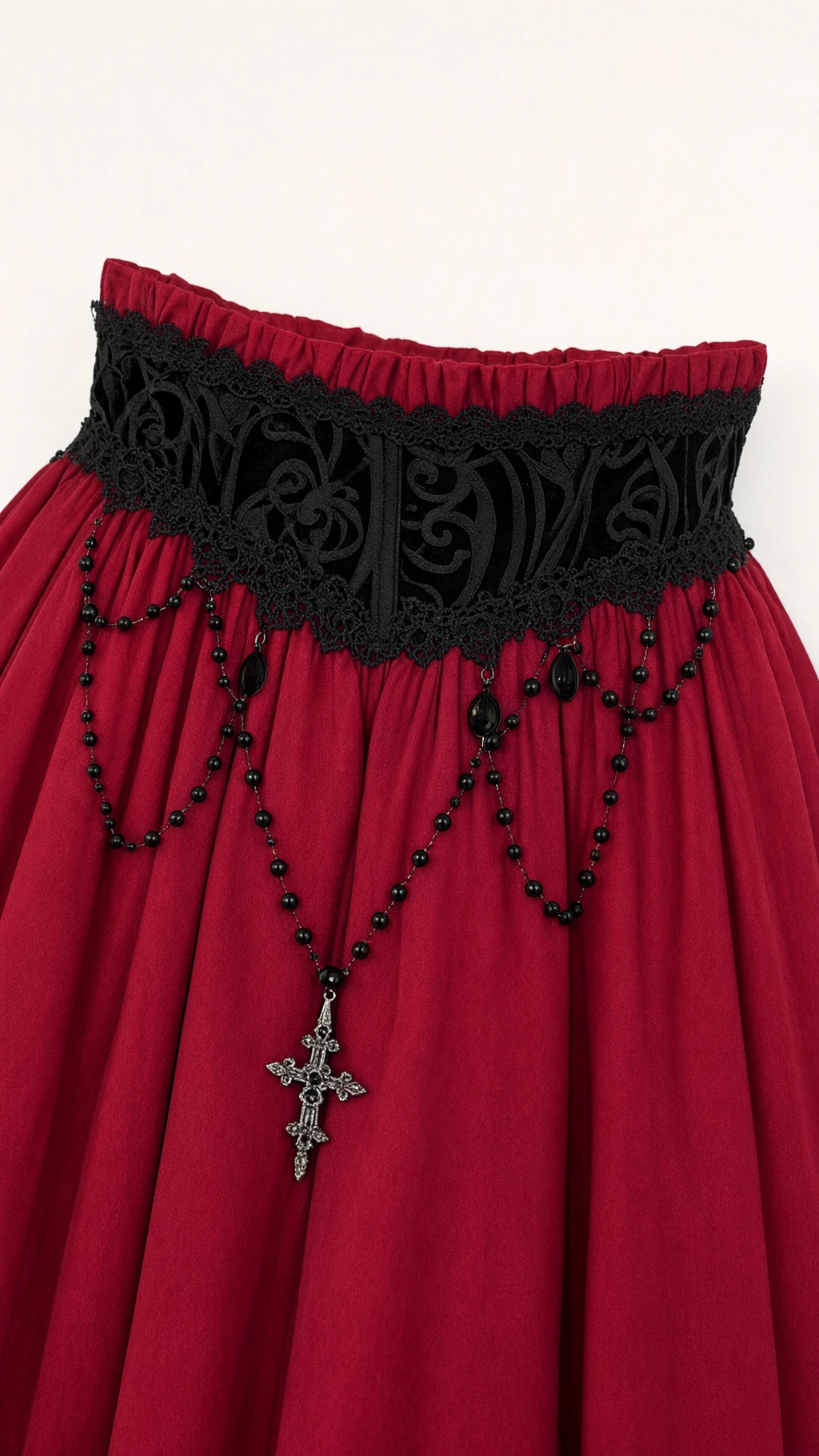 Close-up detail of black lace waist cincher panel with draped black beads and Gothic cross pendant